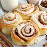 Three cinnamon rolls on a table.